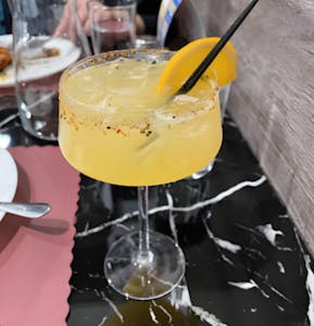 Margarita-style cocktail with chili rim and a lemon wedge
