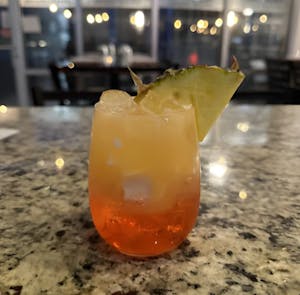 Tropical cocktail in a stemless glass with a pineapple garnish