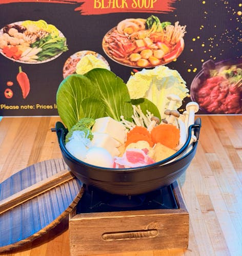 hot pot of greens, tofu, mushrooms, carrots and noodles