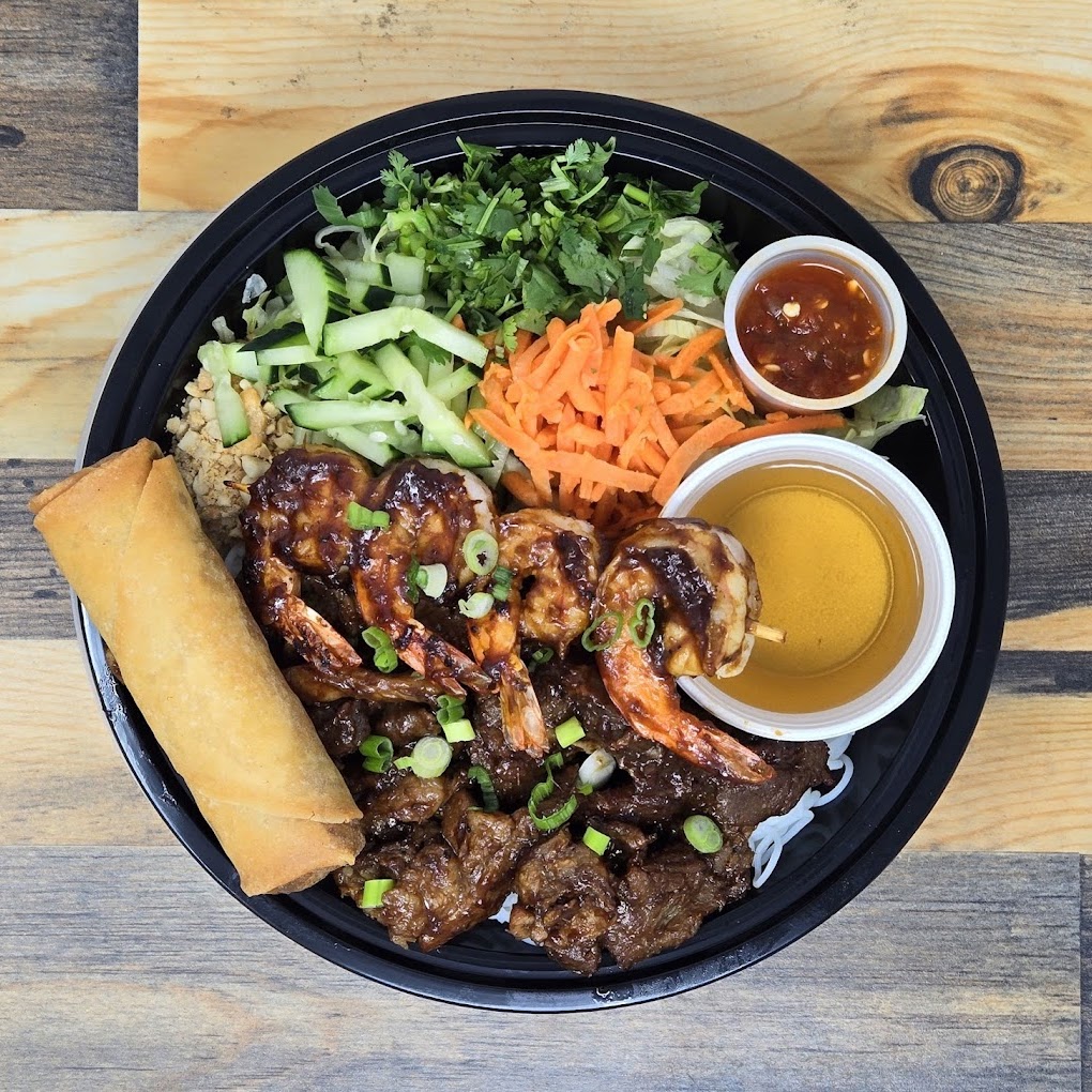 Grilled beef and shrimp over a bed of rice vermicelli noodles