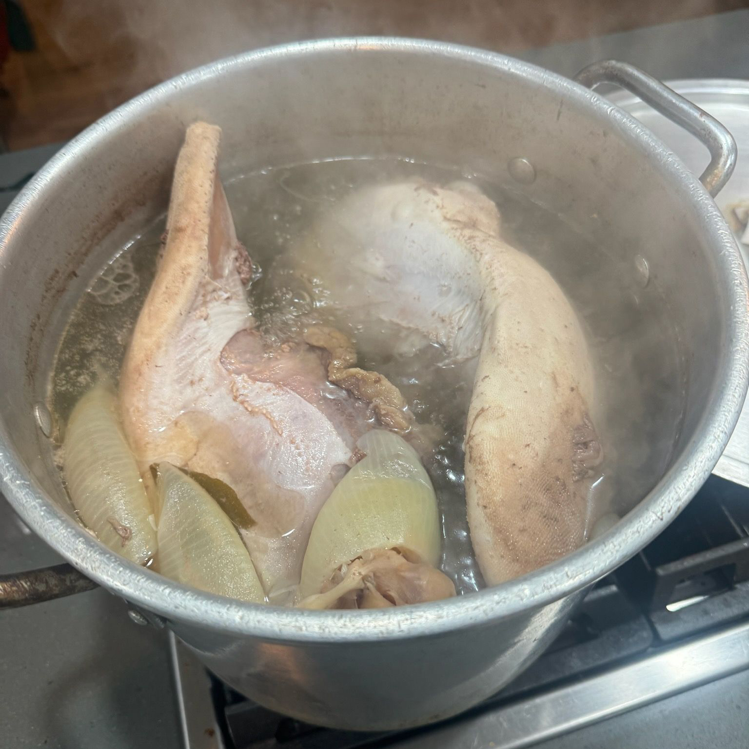 Chicken and onions boiling in a large pot