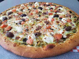 Pizza topped with tomatoes, black olives, red onions, and crumbled white cheese on a herbed sauce