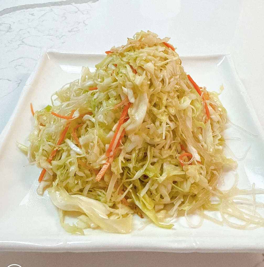 Stir-fried shredded cabbage with carrots on a square white plate