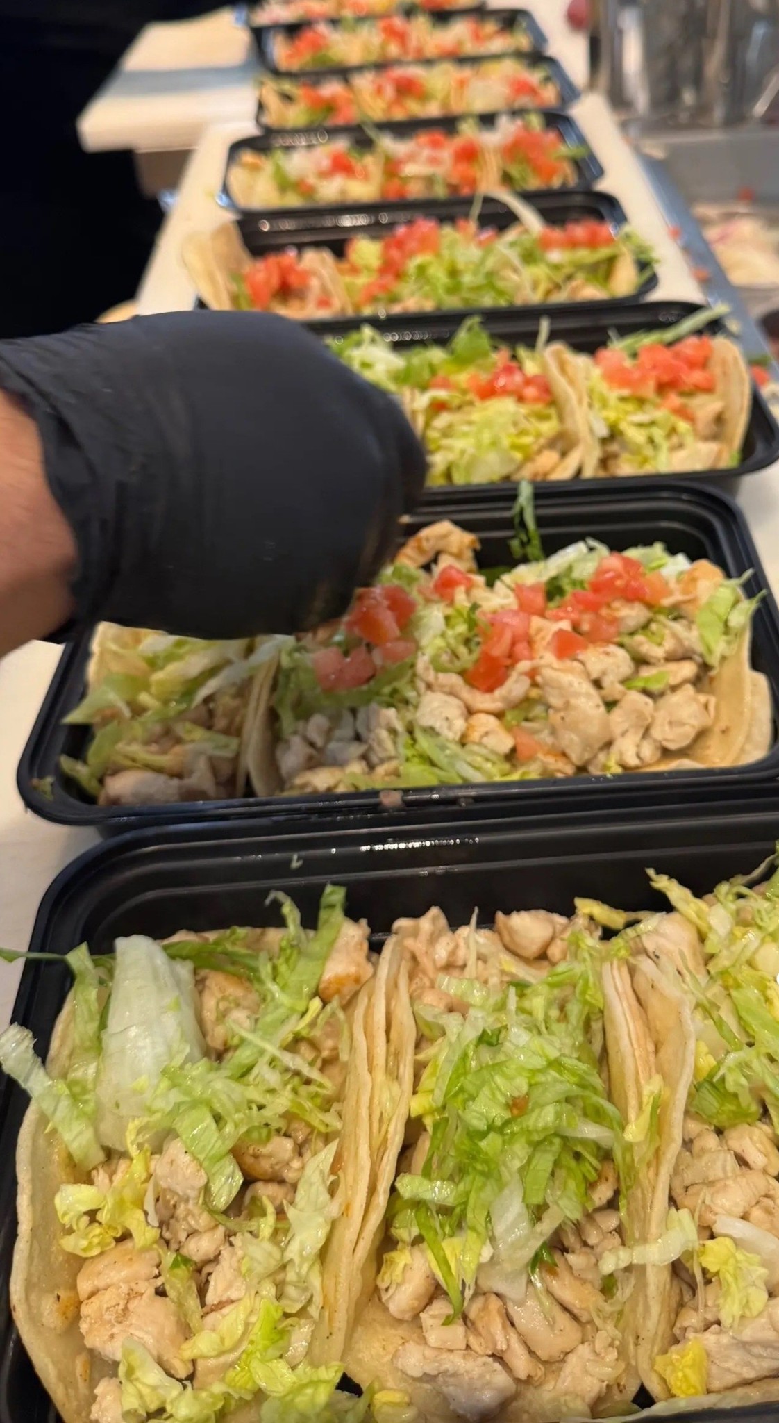Tacos being prepared in takeout containers